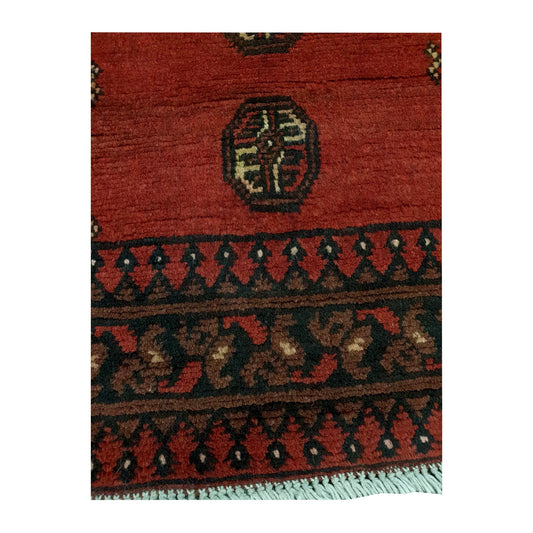 Border and field detail of Afghan Turkoman hand-knotted wool runner rug showing dark charcoal patterning and ivory accents