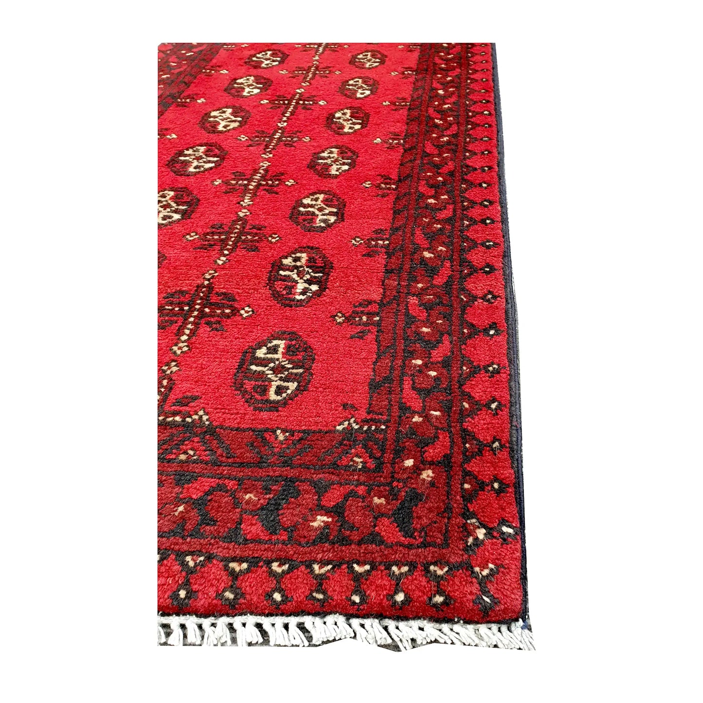 Angled corner and fringe view of Afghan Turkoman hand-knotted wool runner rug showing geometric border and light fringe