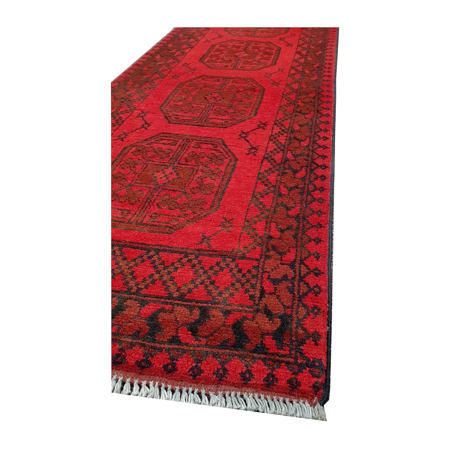Angled corner and fringe view of Afghan Turkoman hand-knotted wool runner rug showing red field, border and light fringe
