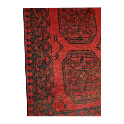 Border and field detail of Afghan Turkoman wool runner rug showing red pile, dark medallions and geometric border