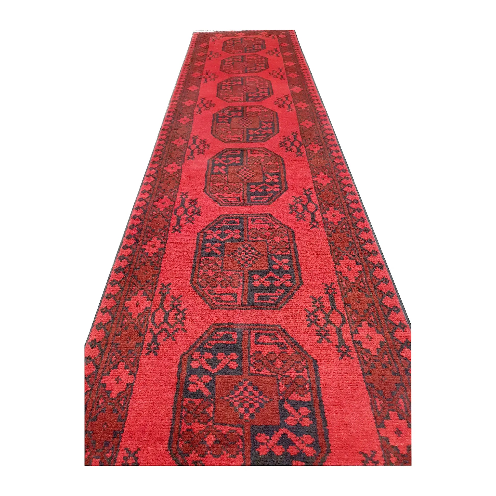 Angled field view of Afghan Turkoman hand-knotted wool runner rug showing repeated medallions and dark border detail