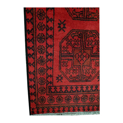Border and field detail of Afghan Turkoman hand-knotted wool runner rug showing red pile, dark medallions and geometric border