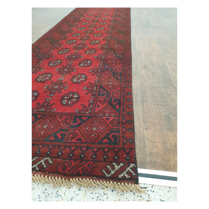Angled detail of Turkoman runner showing border pattern, fringe, and hand-knotted wool texture, 568 x 75 cm