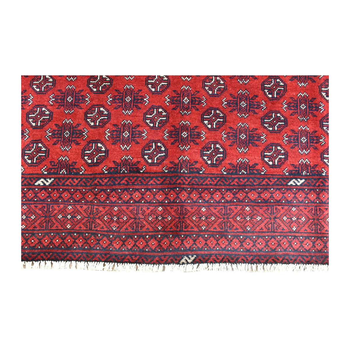 Fringed end of the Afghan Turkoman rug showing rows of dark guls above layered diamond and stepped borders