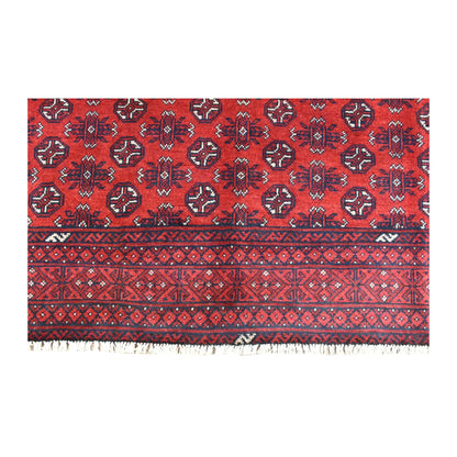 Fringed end of the Afghan Turkoman rug showing rows of dark guls above layered diamond and stepped borders