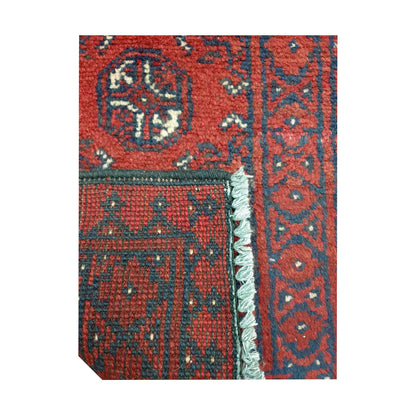 Folded corner detail of Afghan Turkoman red wool rug showing the back, fringe and red front pattern