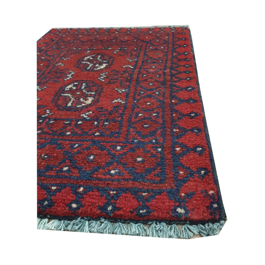 Fringe and border detail of Afghan Turkoman red wool rug showing navy edging, red field and traditional tribal motifs