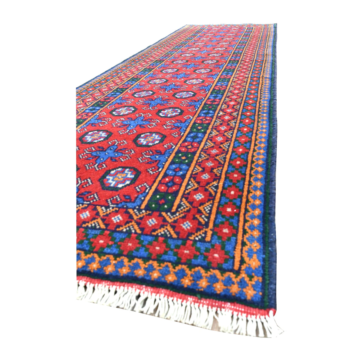 Angled view of Afghan Turkoman runner showing its red geometric field, colourful layered borders and pale fringe