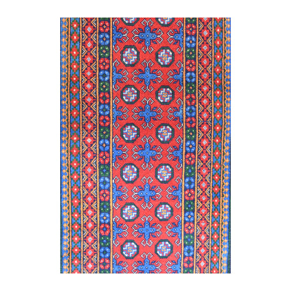 Field detail of Afghan Turkoman runner showing paired octagonal medallions and blue four-pointed motifs across the red ground