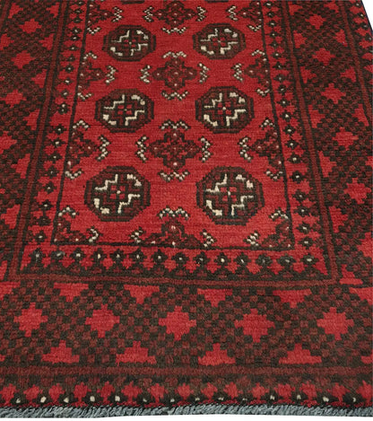 End field and border detail of Afghan Turkoman rug with repeated gul medallions and red-black tribal pattern