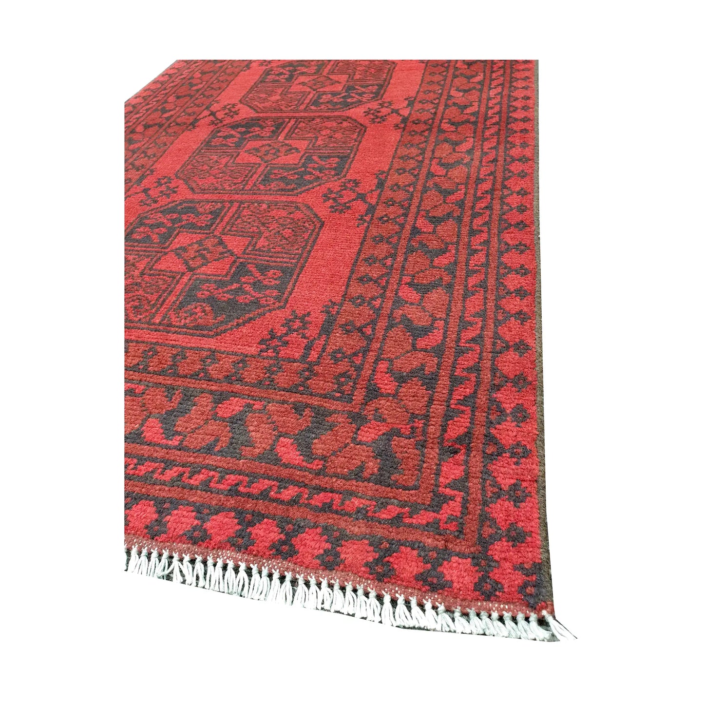 Angled fringe and corner detail of Afghan Turkoman rug showing red wool pile and dark geometric border