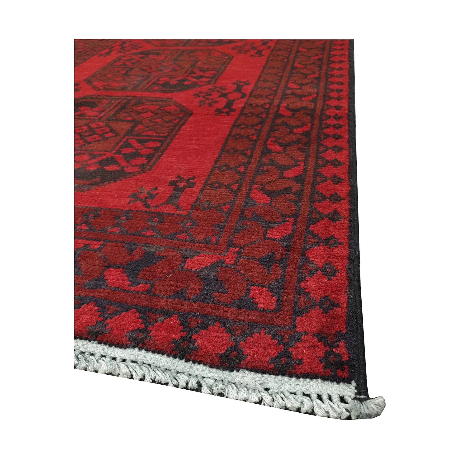 Angled fringe and corner detail of Afghan Turkoman rug showing red wool pile and dark geometric border