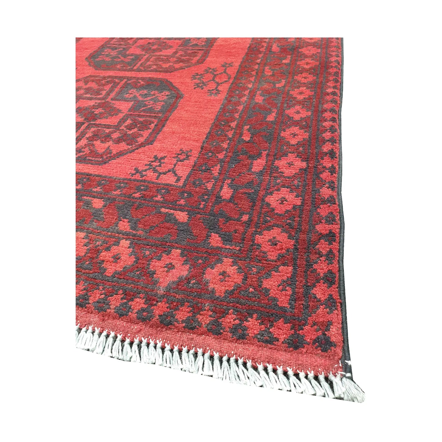 Angled fringe and corner detail of Afghan Turkoman rug showing red wool pile and dark geometric border