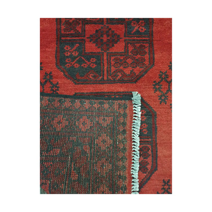 Folded corner detail of Afghan Turkoman rug showing the back of the rug, fringe and red front pattern
