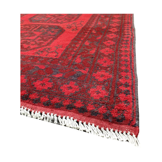 Angled fringe and corner detail of Afghan Turkoman rug showing red wool pile and dark geometric border