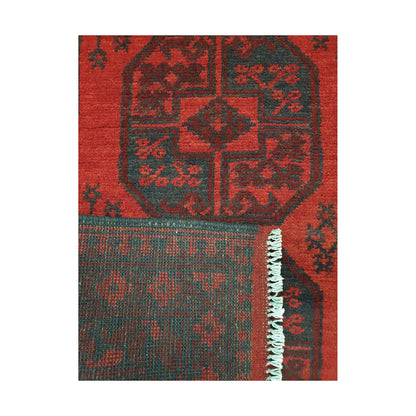 Folded corner detail of Afghan Turkoman rug showing the back of the rug, fringe and red front pattern