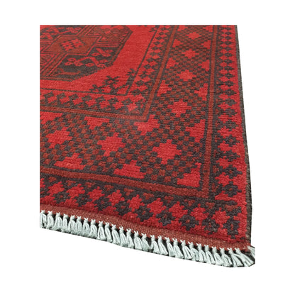 Angled fringe and corner detail of Afghan Turkoman rug showing red wool pile and dark geometric border