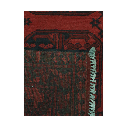 Folded corner detail of Afghan Turkoman rug showing the back of the rug, fringe and red front pattern