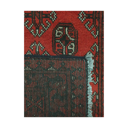 Folded corner detail of Afghan Turkoman rug showing the back of the rug, fringe and red front pattern