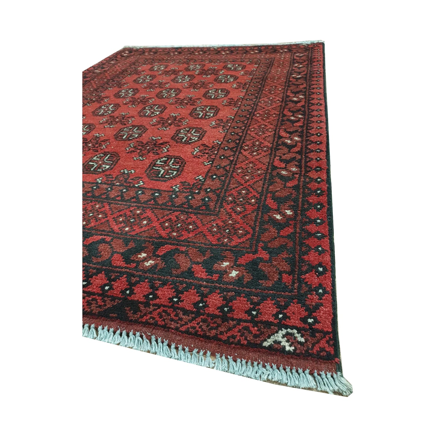 Angled border and fringe detail of Afghan Turkoman rug showing red wool pile, charcoal edging and tribal motifs