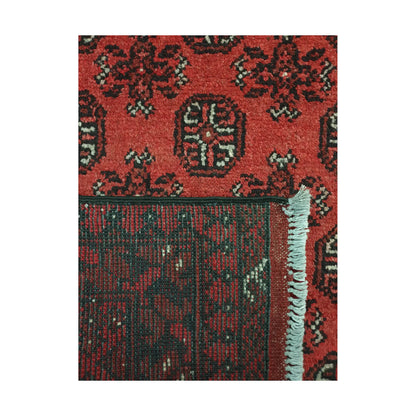 Folded corner detail of Afghan Turkoman rug showing the back of the rug, fringe and red front pattern