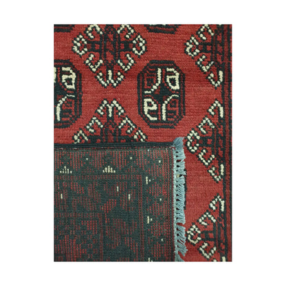 Folded corner detail of Afghan Turkoman rug showing the back of the rug, fringe and red front pattern