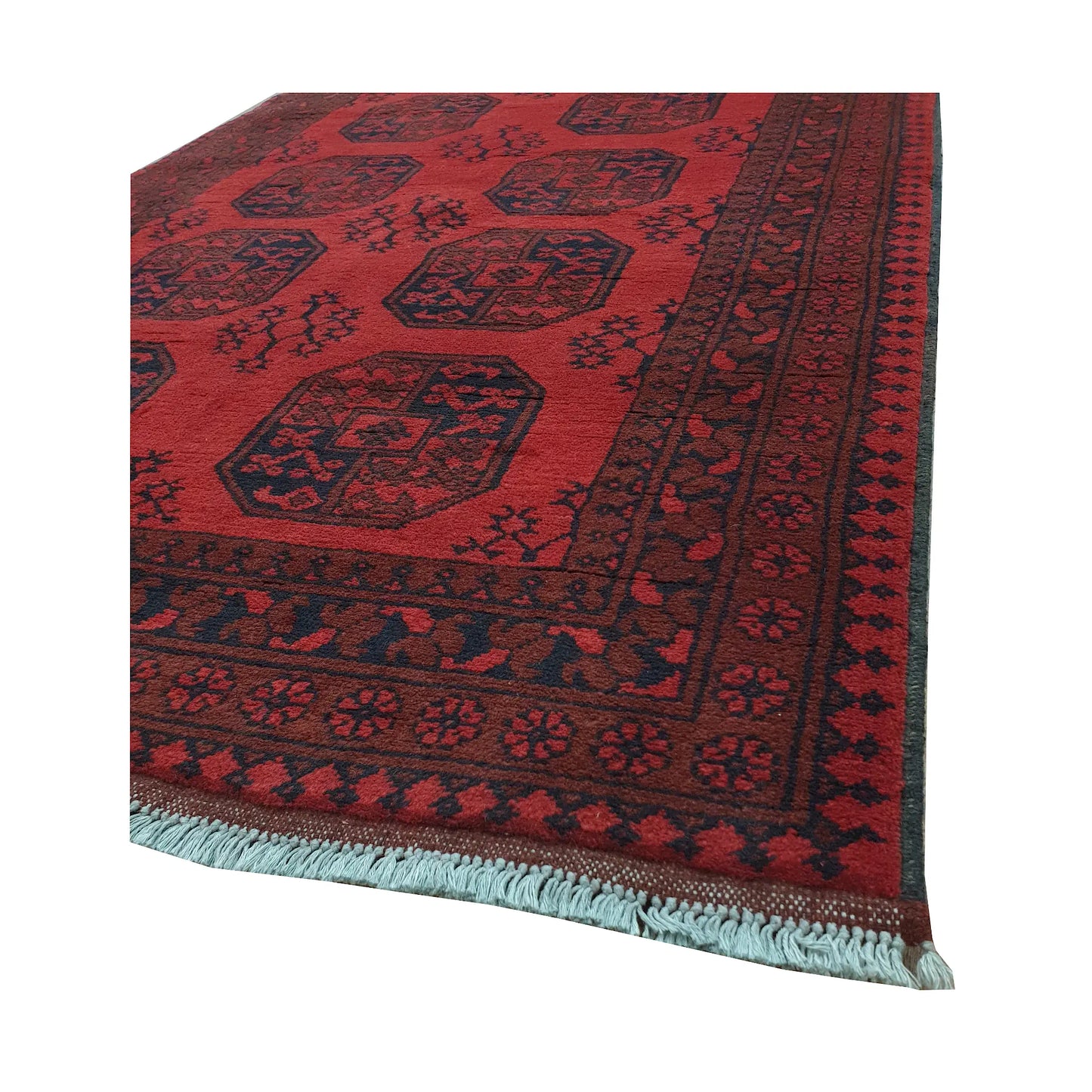 Angled border and fringe detail of Afghan Turkoman rug showing red wool pile, charcoal motifs and geometric edging