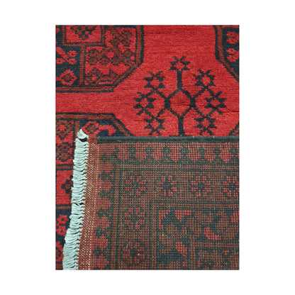 Folded corner detail of Afghan Turkoman rug showing the back of the rug, fringe and red front pattern