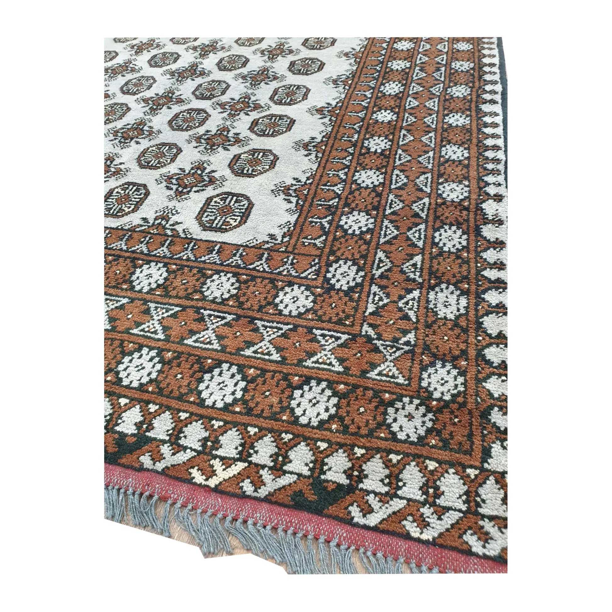 Angled border-corner detail of Afghan Turkoman rug showing the geometric pattern and visible fringe