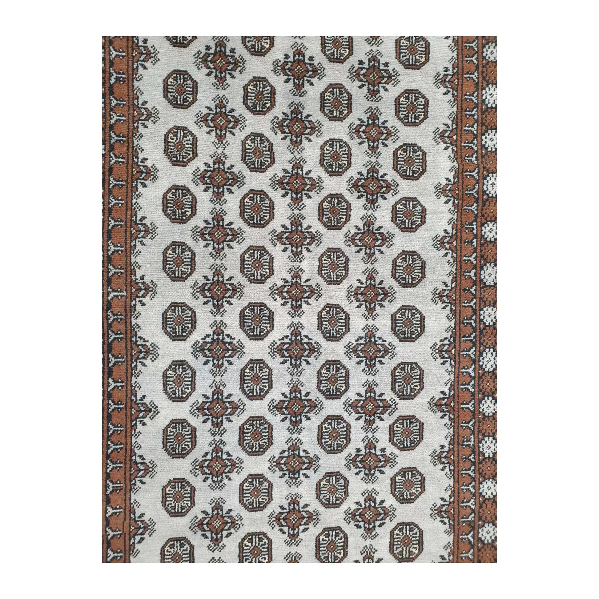 Close-up of Afghan Turkoman rug showing the repeating gul motifs across the off-white field
