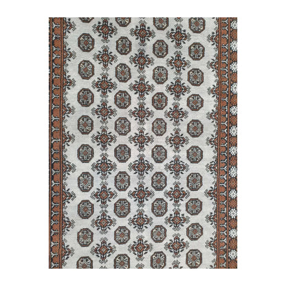 Close-up of Afghan Turkoman rug showing the repeating gul motifs across the off-white field
