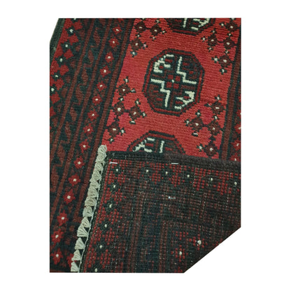Folded-corner detail of Afghan Turkoman runner rug showing the patterned field, reverse weave and rug edge