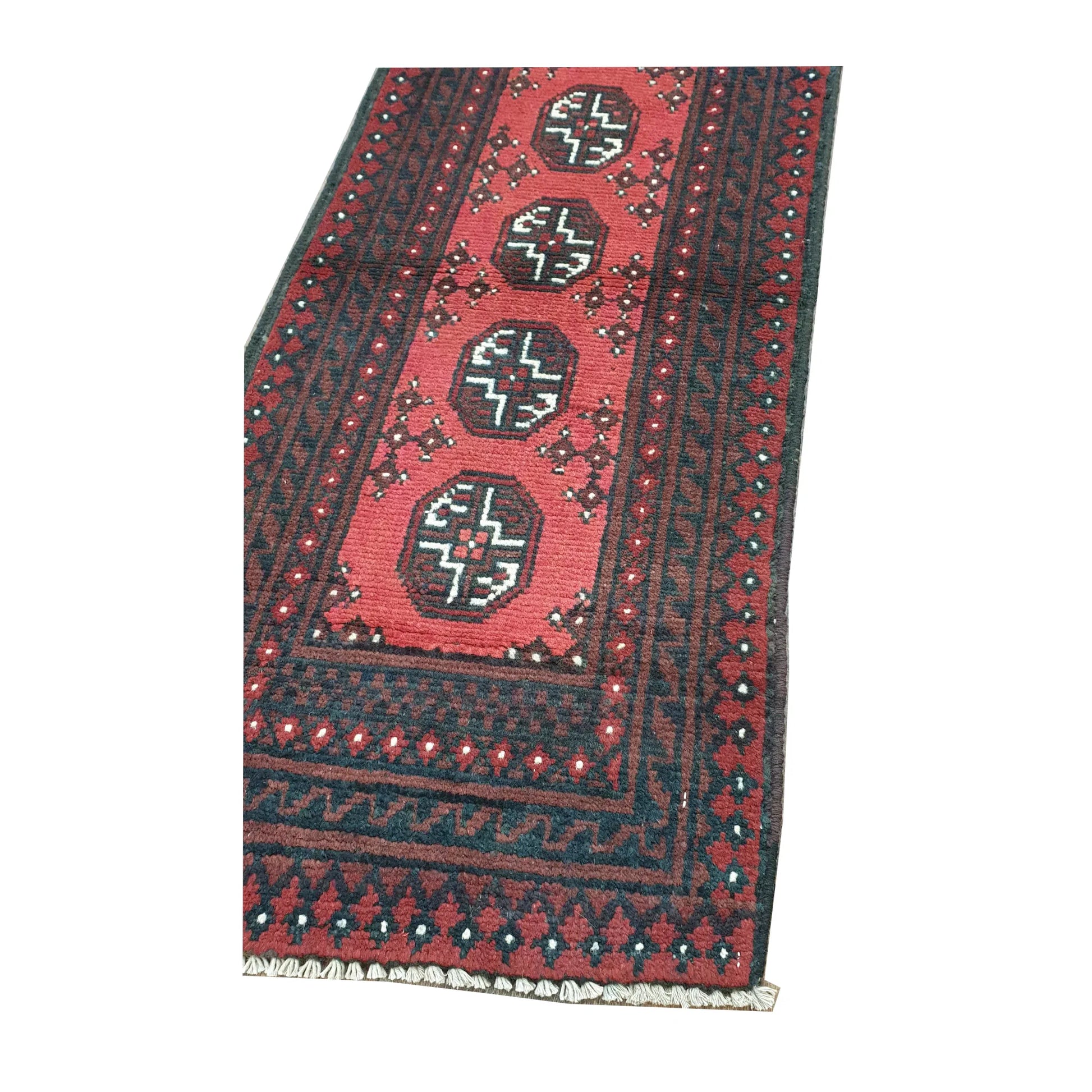 Angled close-up of Afghan Turkoman runner rug showing the lower field, octagonal gul motifs and layered end border
