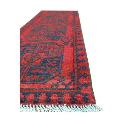 Angled border and fringe detail of Afghan Turkoman runner rug showing red wool pile, charcoal edging and tribal motifs