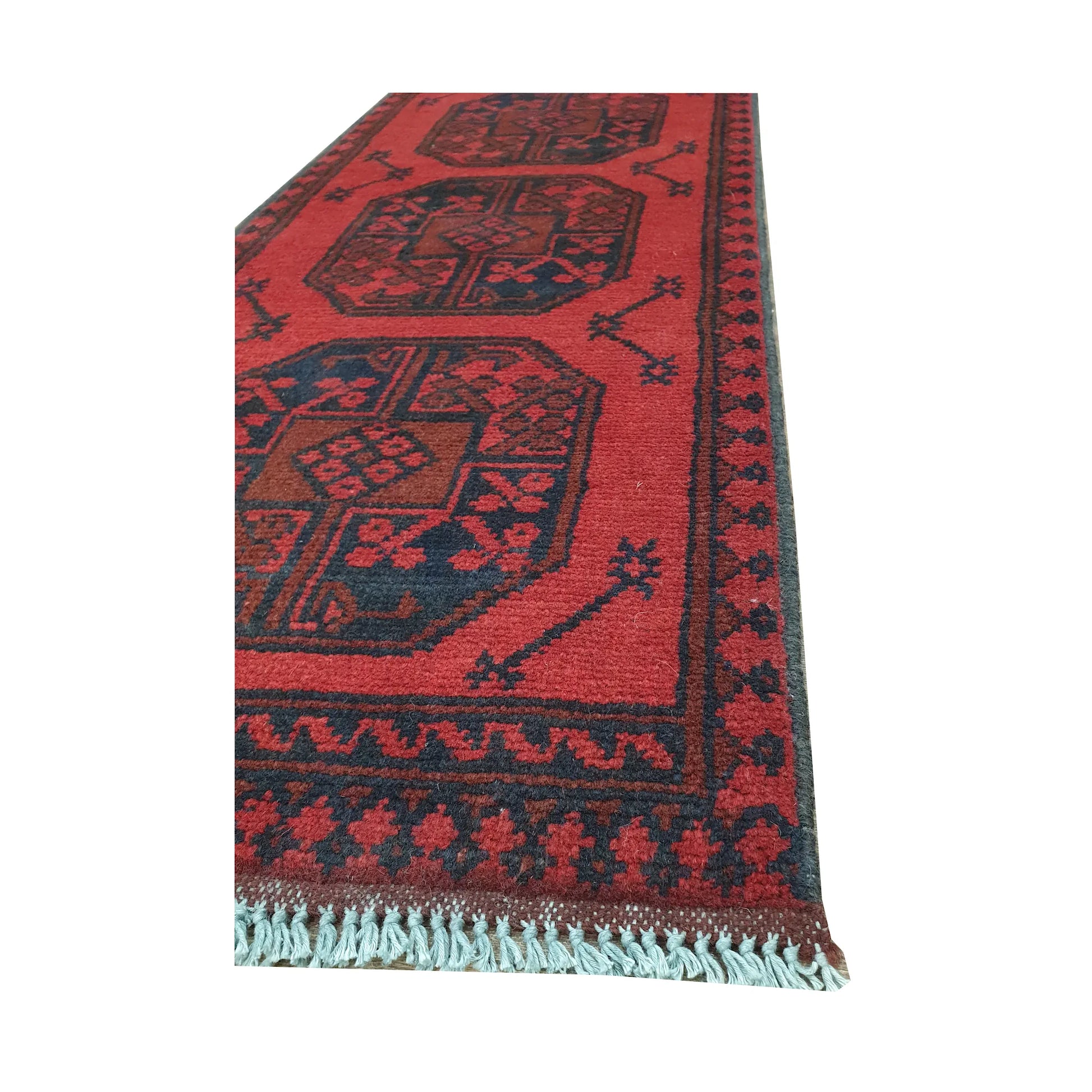 Angled border and fringe detail of Afghan Turkoman runner rug showing red wool pile, charcoal edging and tribal motifs