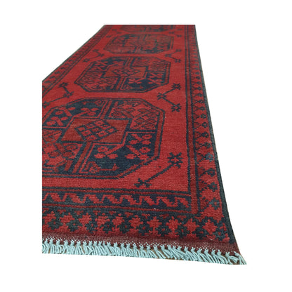 Angled border and fringe detail of Afghan Turkoman runner rug showing red wool pile, charcoal edging and tribal motifs