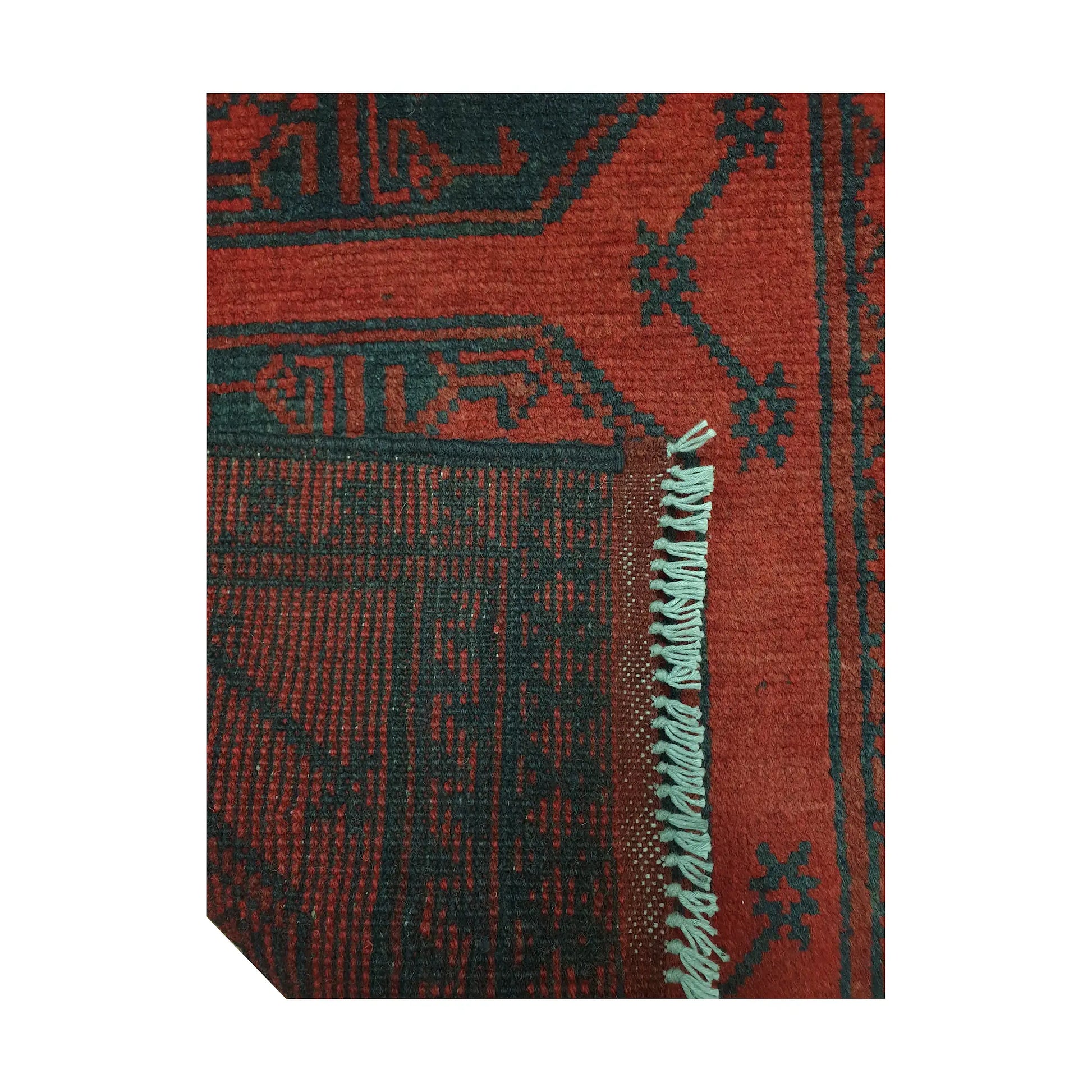 Folded corner detail of Afghan Turkoman runner rug showing the back of the rug, fringe and red front pattern