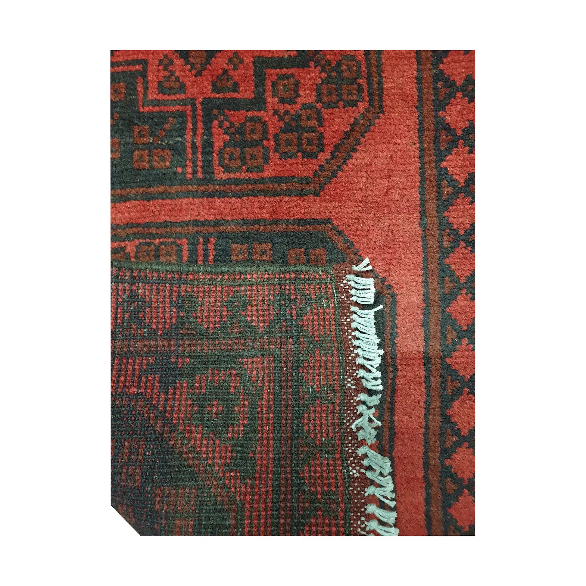Folded corner detail of Afghan Turkoman runner rug showing the back of the rug, fringe and red front pattern