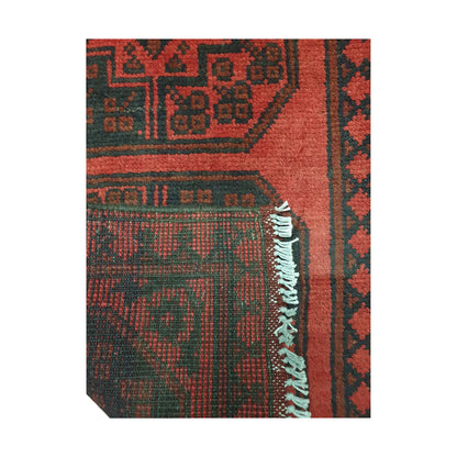Folded corner detail of Afghan Turkoman runner rug showing the back of the rug, fringe and red front pattern