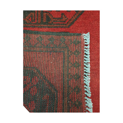 Folded corner detail of Afghan Turkoman runner rug showing the back of the rug, fringe and red front pattern