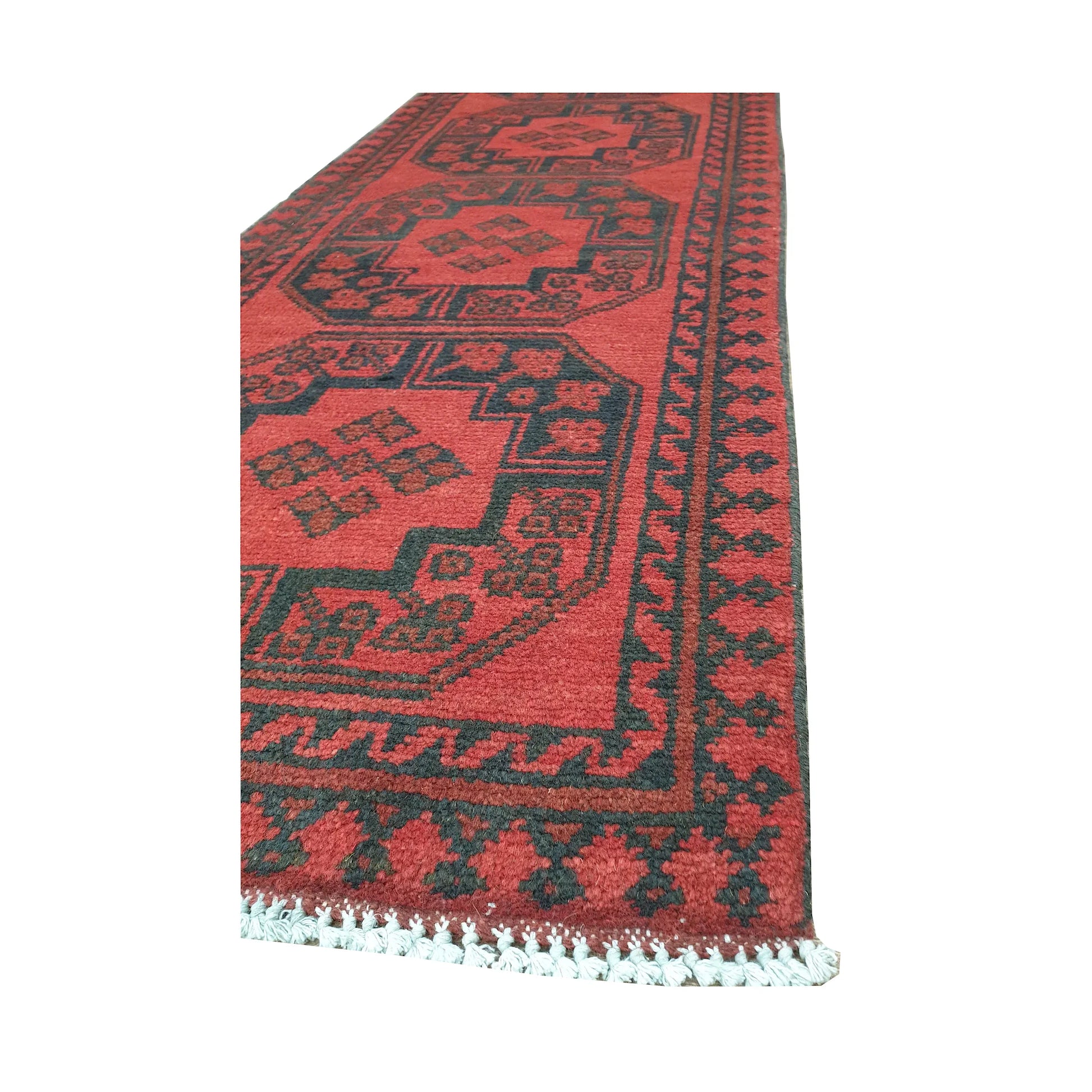Angled border and fringe detail of Afghan Turkoman runner rug showing red wool pile, charcoal edging and geometric motifs