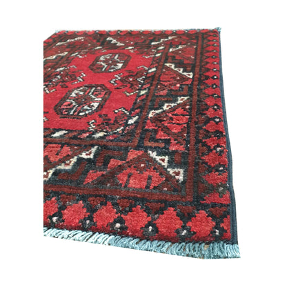 Fringe and border detail of Afghan Turkoman wool rug showing red field, dark edging and tribal pattern