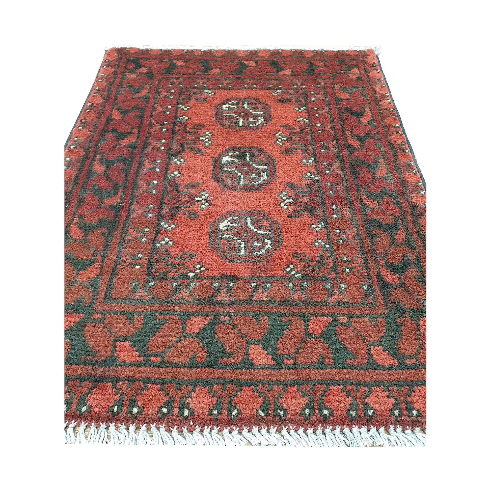 Front view of Afghan Turkoman wool rug showing three rounded guls, warm red field and layered geometric borders