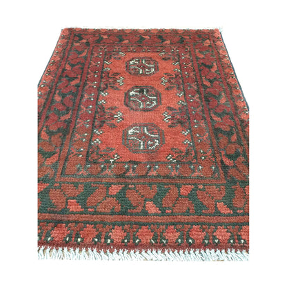 Front view of Afghan Turkoman wool rug showing three rounded guls, warm red field and layered geometric borders