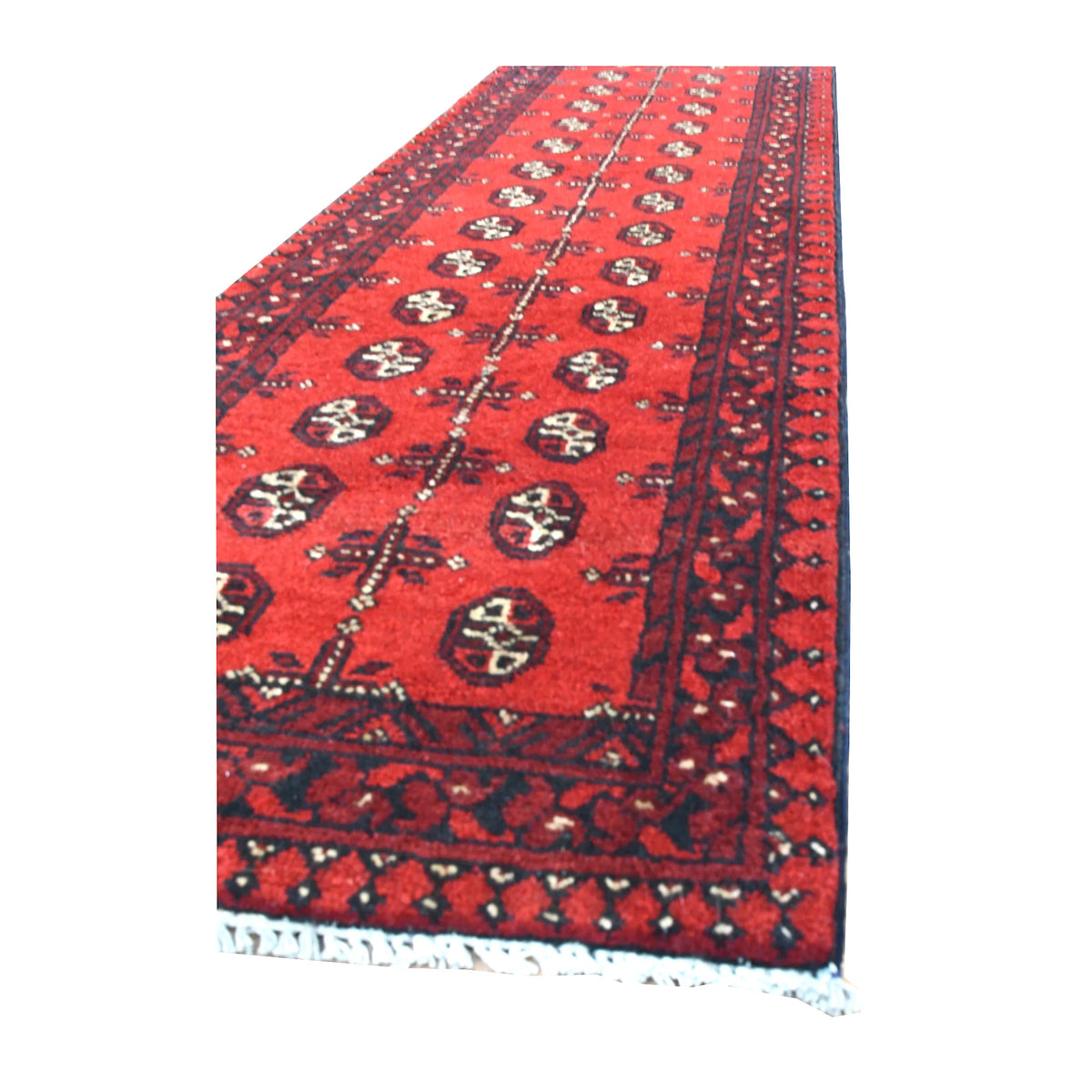 Angled view of Afghan Turkoman runner showing its red gul field, layered charcoal borders and blue-grey fringe