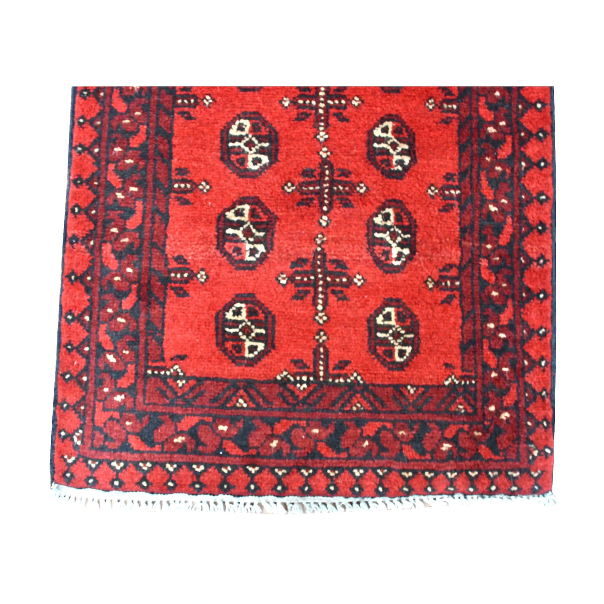 Fringe-end detail of Afghan Turkoman runner showing paired gul motifs, red and charcoal borders and blue-grey fringe