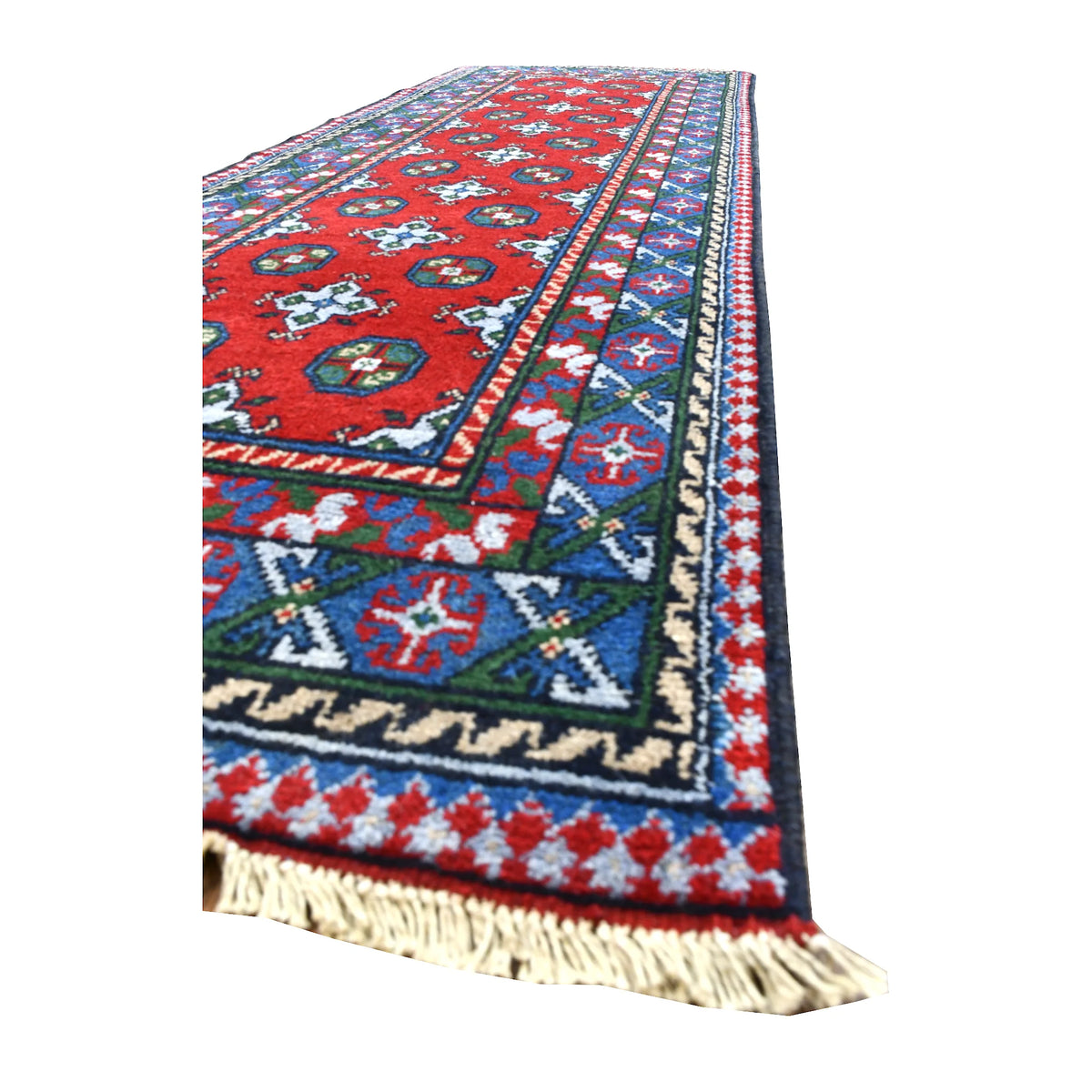 Angled view of Afghan Turkoman runner showing its red gul field, blue and purple geometric borders and ivory fringe