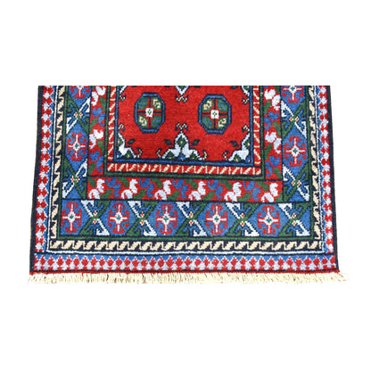 Fringe-end detail of Afghan Turkoman runner showing layered navy, teal, purple and ivory borders around the red field