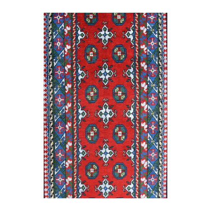 Field detail of Afghan Turkoman wool runner showing paired blue guls, ivory star-like forms and jewel-toned geometric borders