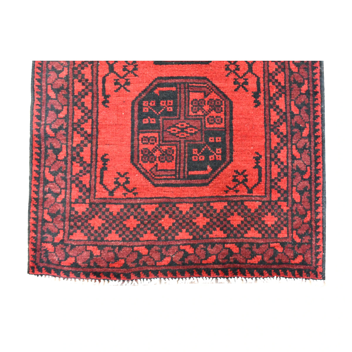 Fringe-end detail of Afghan Turkoman runner showing a dark octagonal gul, red geometric borders and ivory fringe